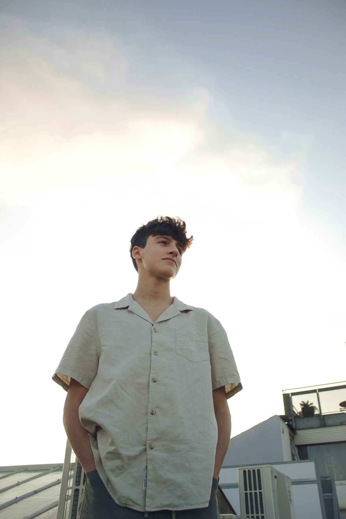 Modelo usando camisa de linho em tom areia em um telhado ao fim da tarde